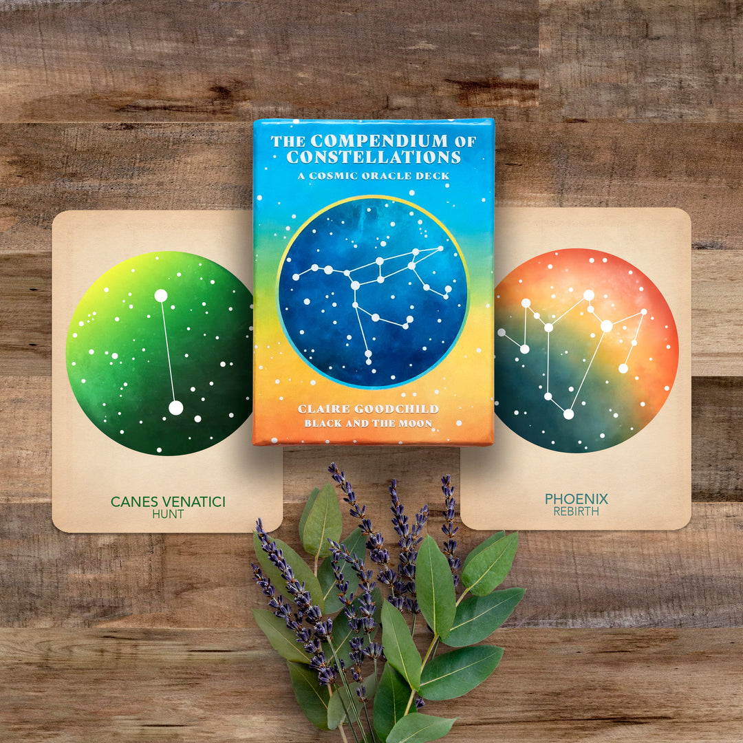 compendium of constellations oracle deck box and two cards on a wooden background